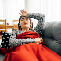 A women holding her head because of sickness