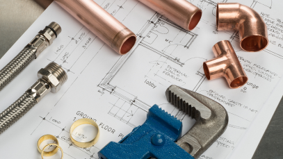 Copper pipe fittings and a wrench on plumbing drawings